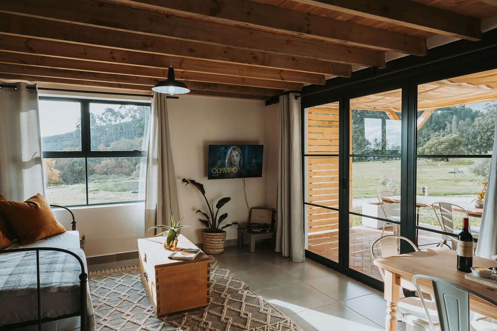 Living room of the Farm Cottage with glass doors open onto the valley