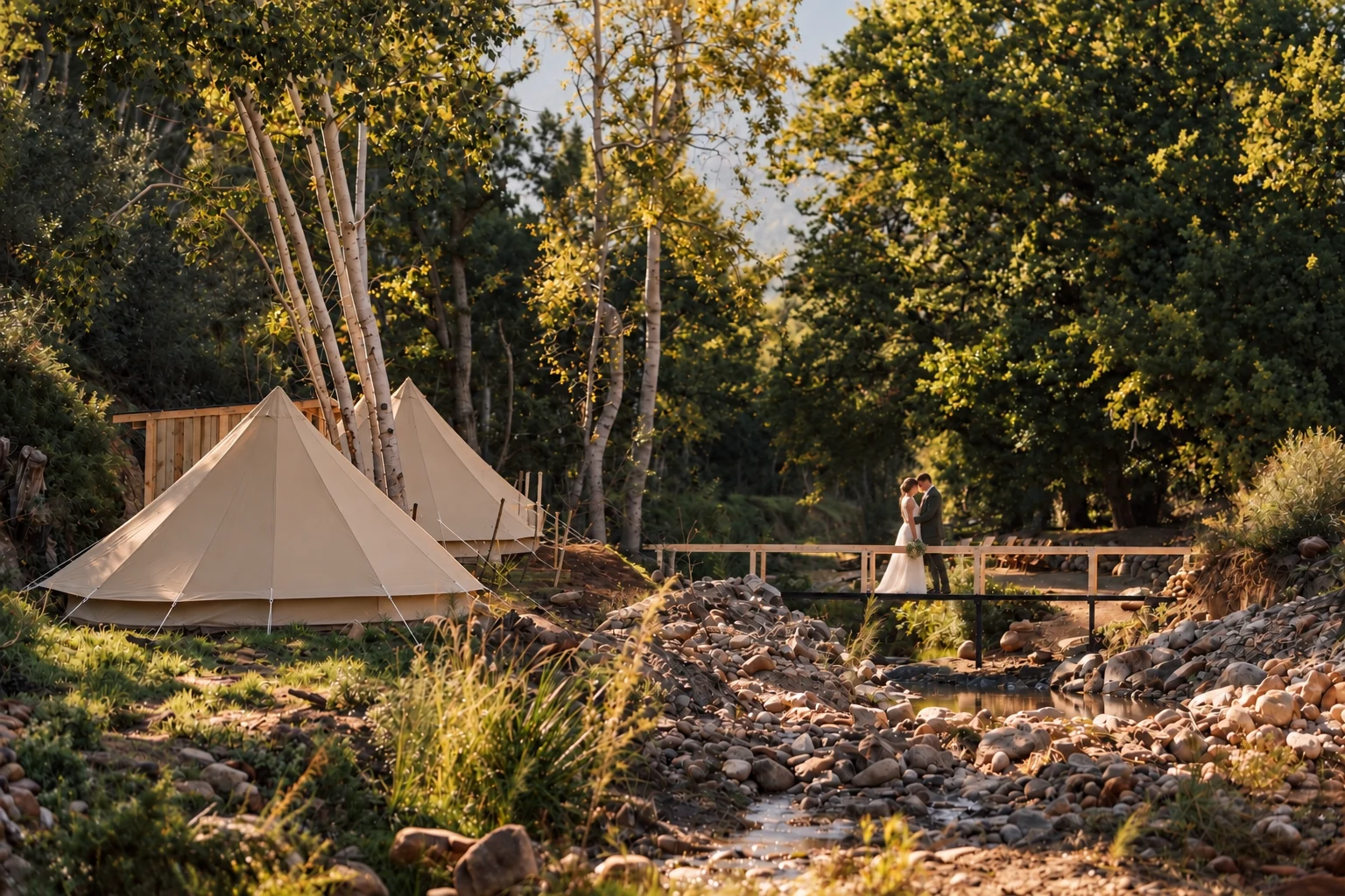 Canvas tent beside the creek and wooden bridge in golden light