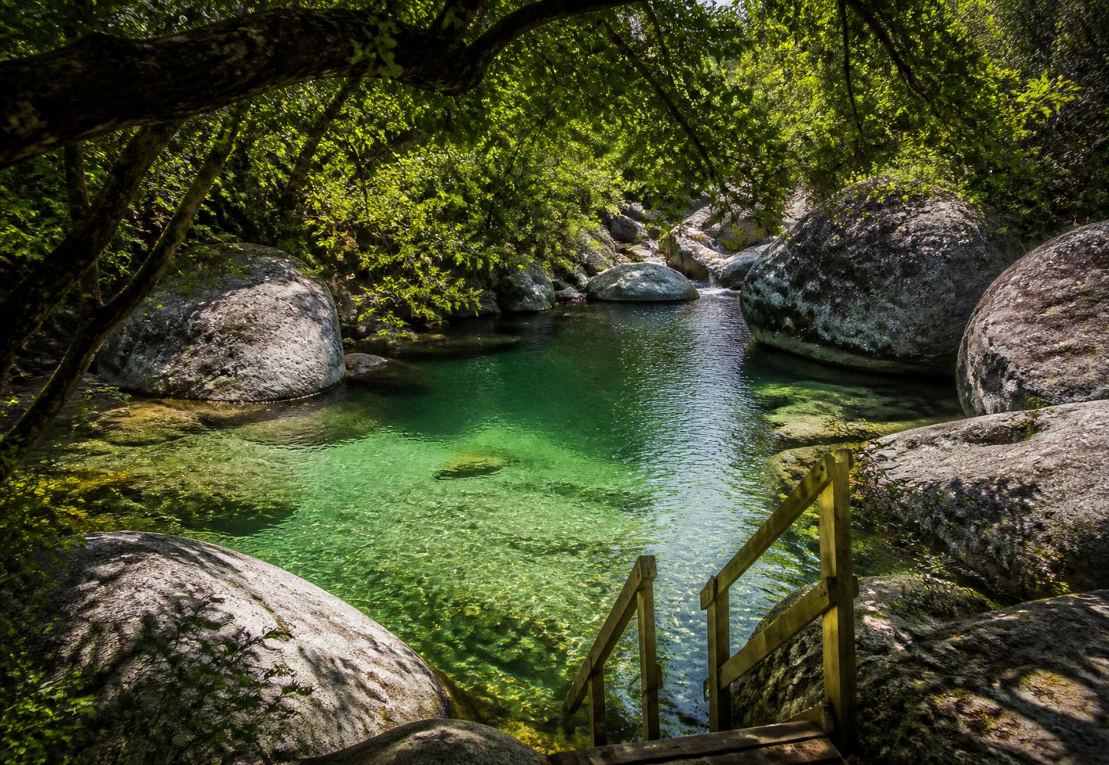 Clear river swimming pool between granite boulders on the farm