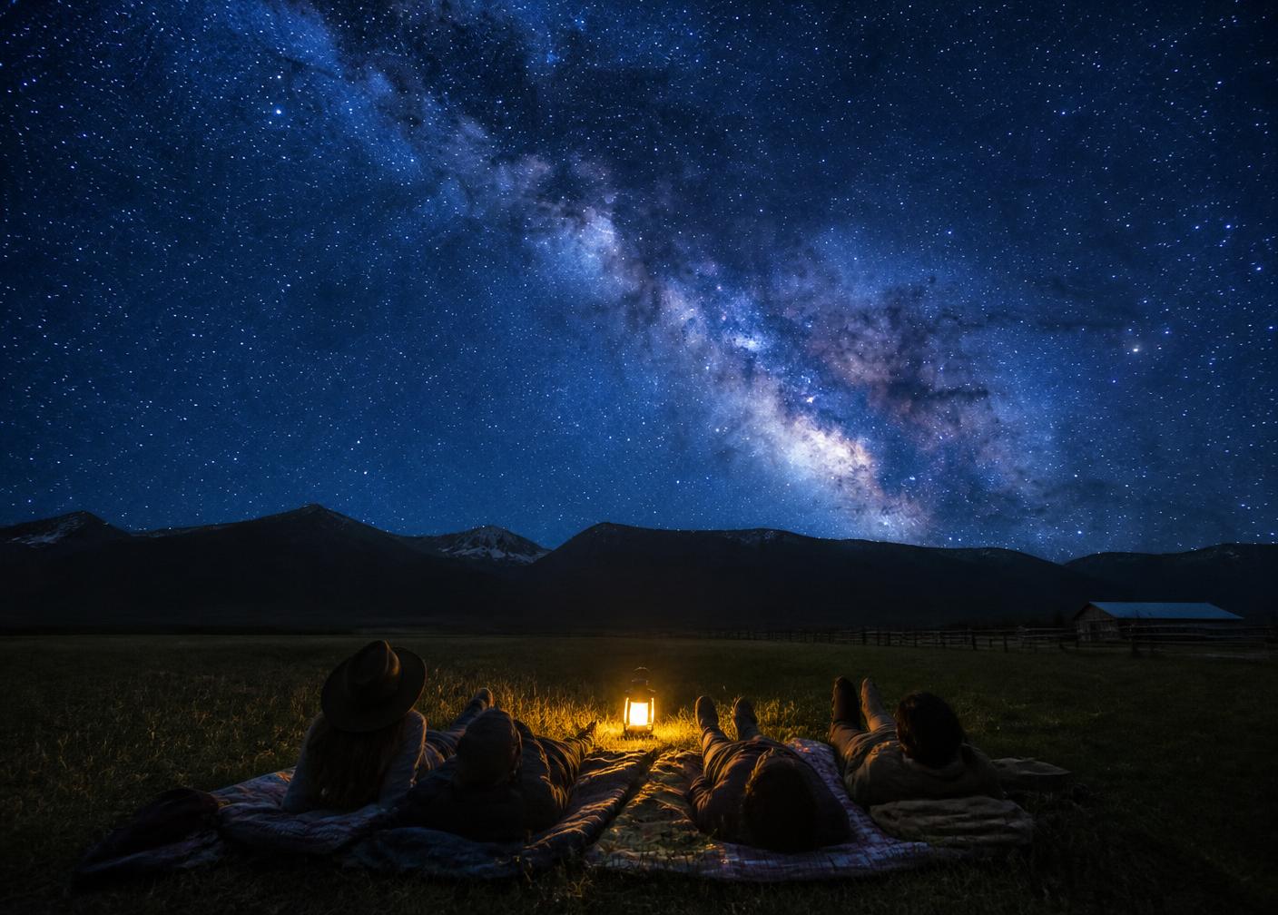 Guests lying on blankets looking at the Milky Way above the farm